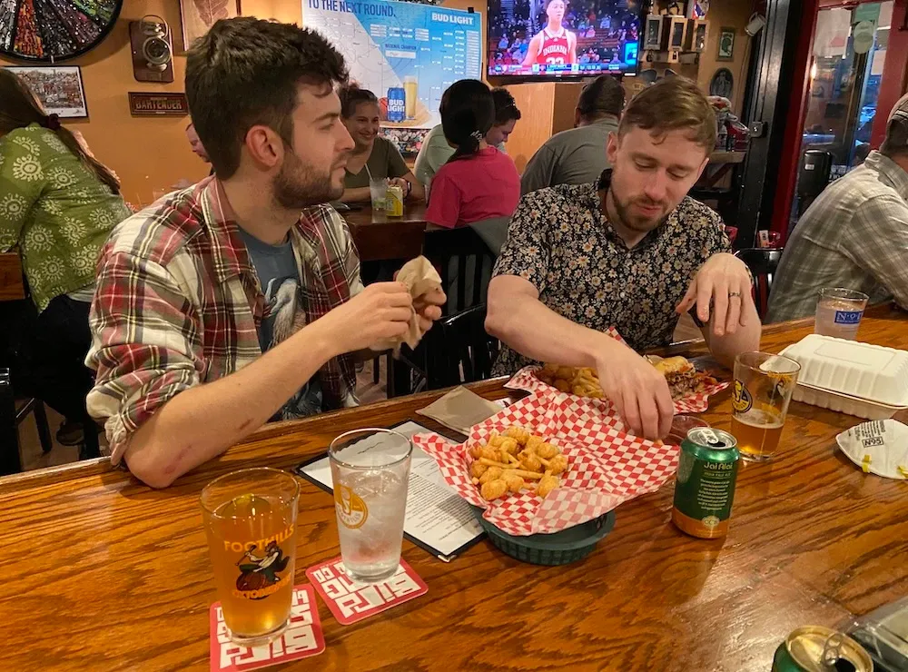 Friends Sean and Scott, Duke Law and Fuqua alums, sharing tater tots at the bar